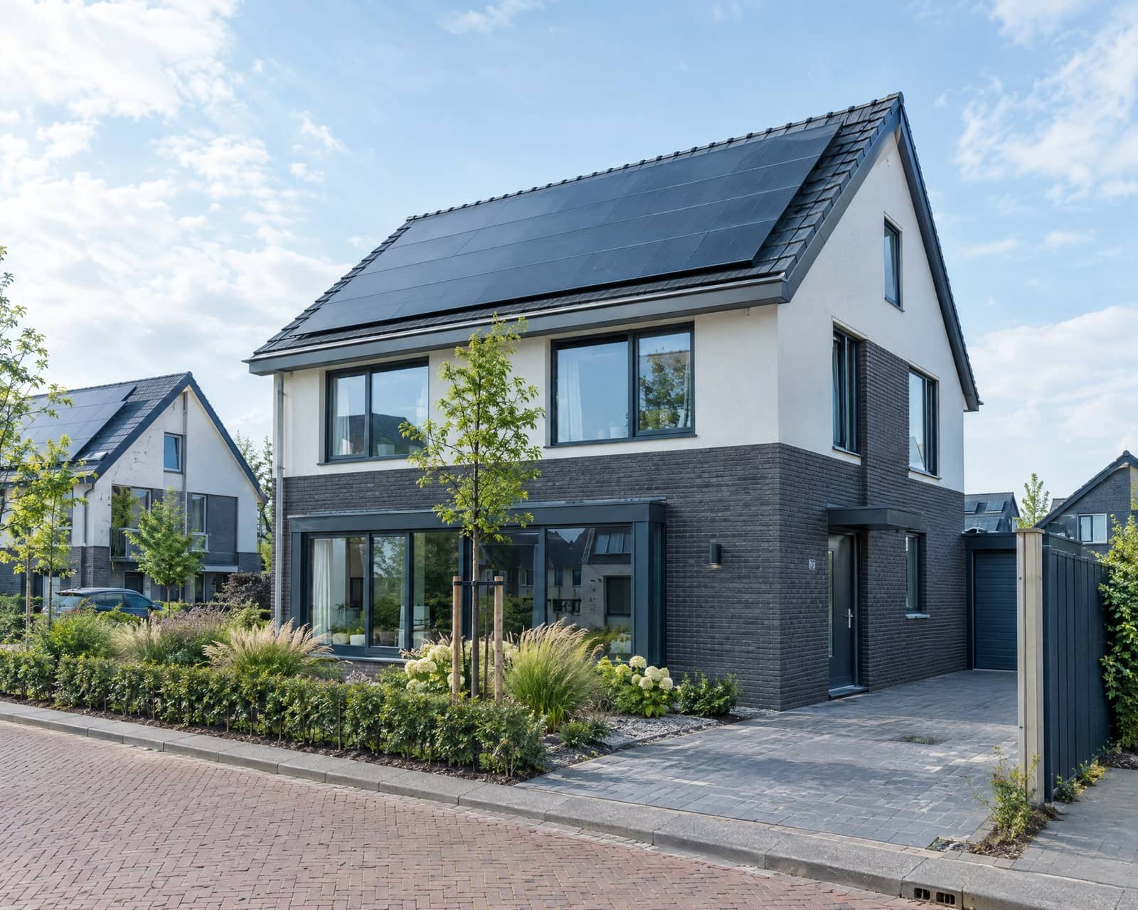 Moderne Nederlandse nieuwbouwwoning met zwarte zonnepanelen op het dak, symbool voor verduurzaming van woningen