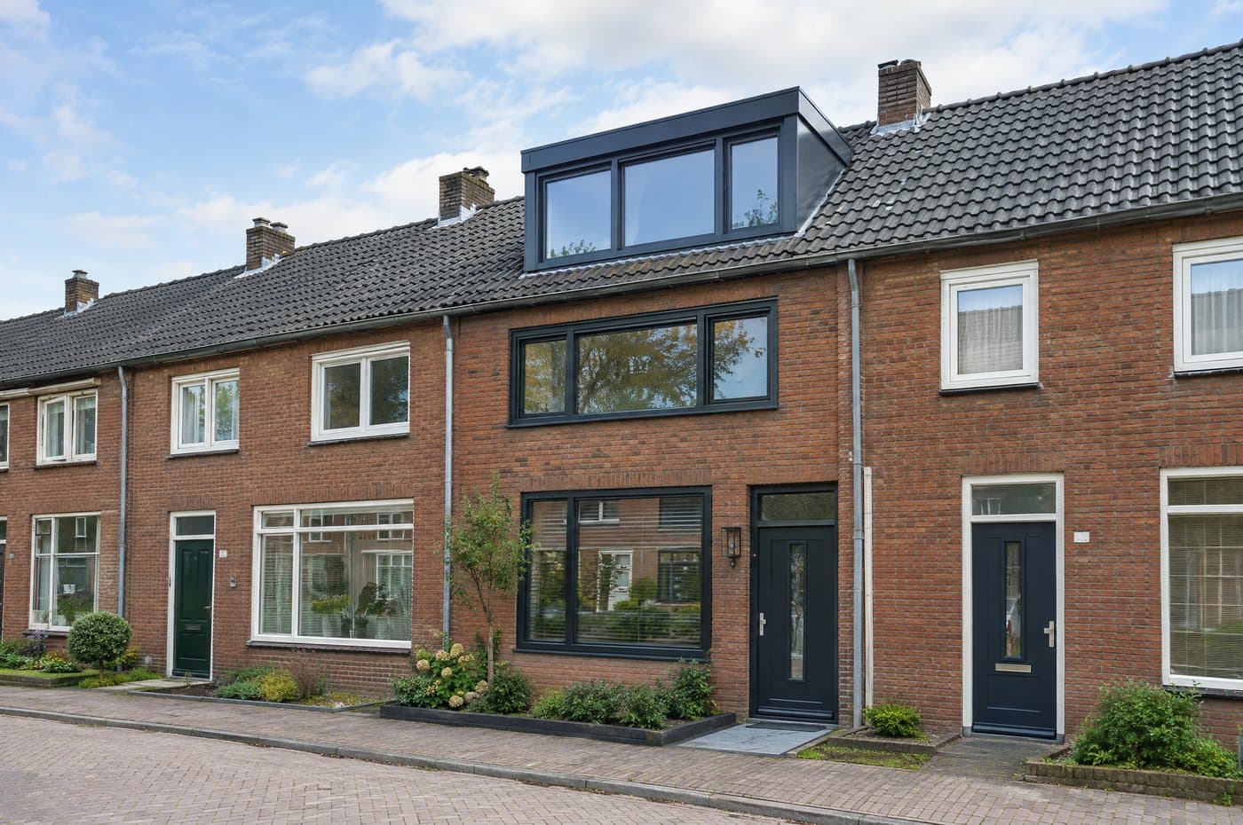 Nederlandse rijwoning met een nieuwe dakkapel en antraciete kozijnen na renovatie